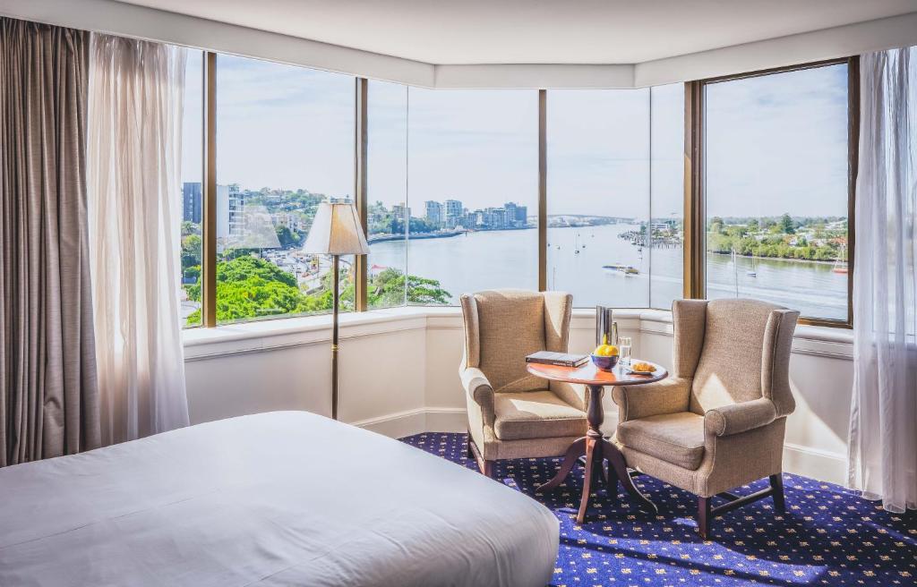 een hotelkamer met een bed, twee stoelen en een tafel bij View Brisbane in Brisbane