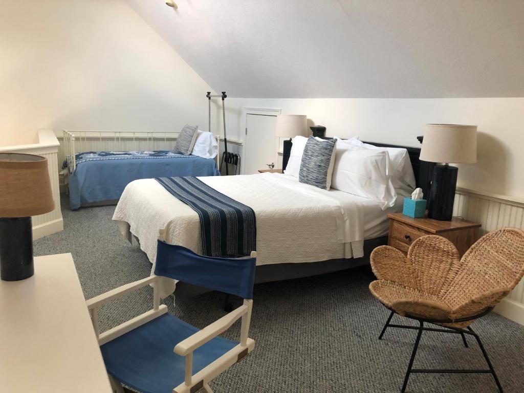 a bedroom with a bed and a blue chair at Chapman House in Put-in-Bay