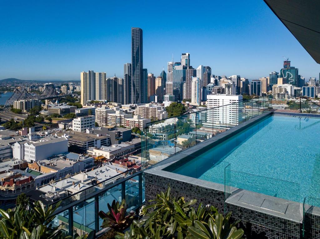 een zwembad en uitzicht op de skyline van de stad bij Fortitude Valley Apartments by CLLIX in Brisbane