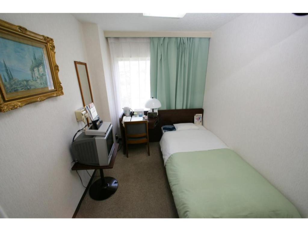 a hotel room with two beds and a television at Business Hotel Heisei - Vacation STAY 90553 in Yonezawa