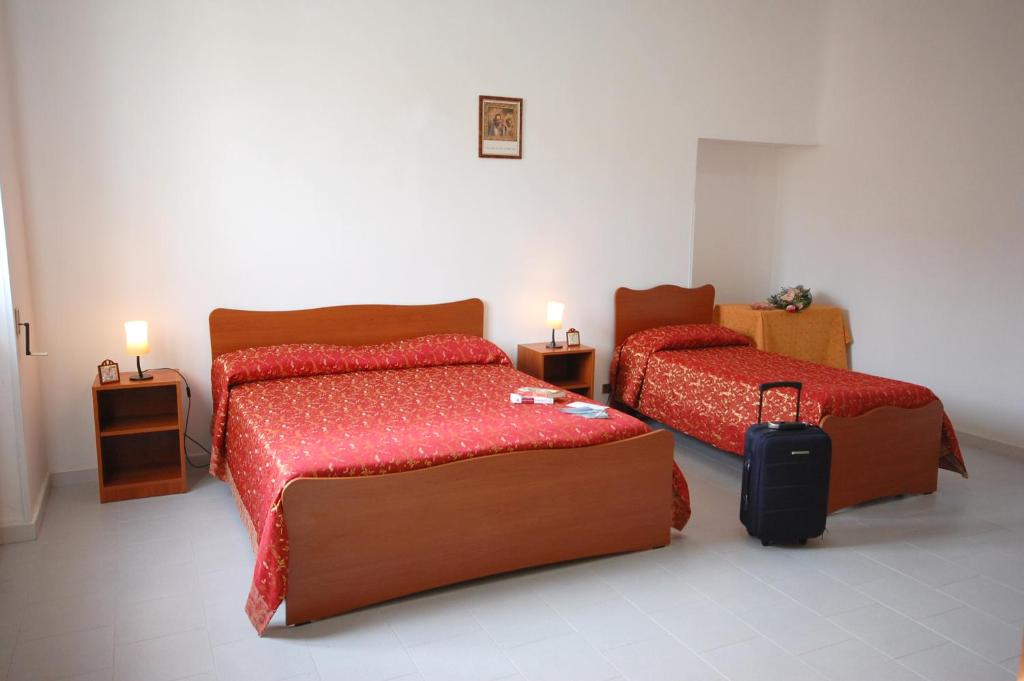 萊烏卡的住宿－阿爾伯托德塞圖里奧酒店，一间卧室配有两张床和行李箱