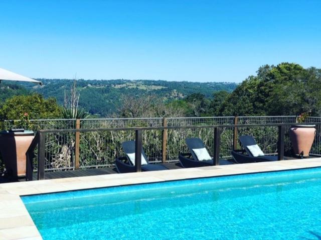 a swimming pool with lounge chairs on a balcony at Montville Holiday Apartments in Montville