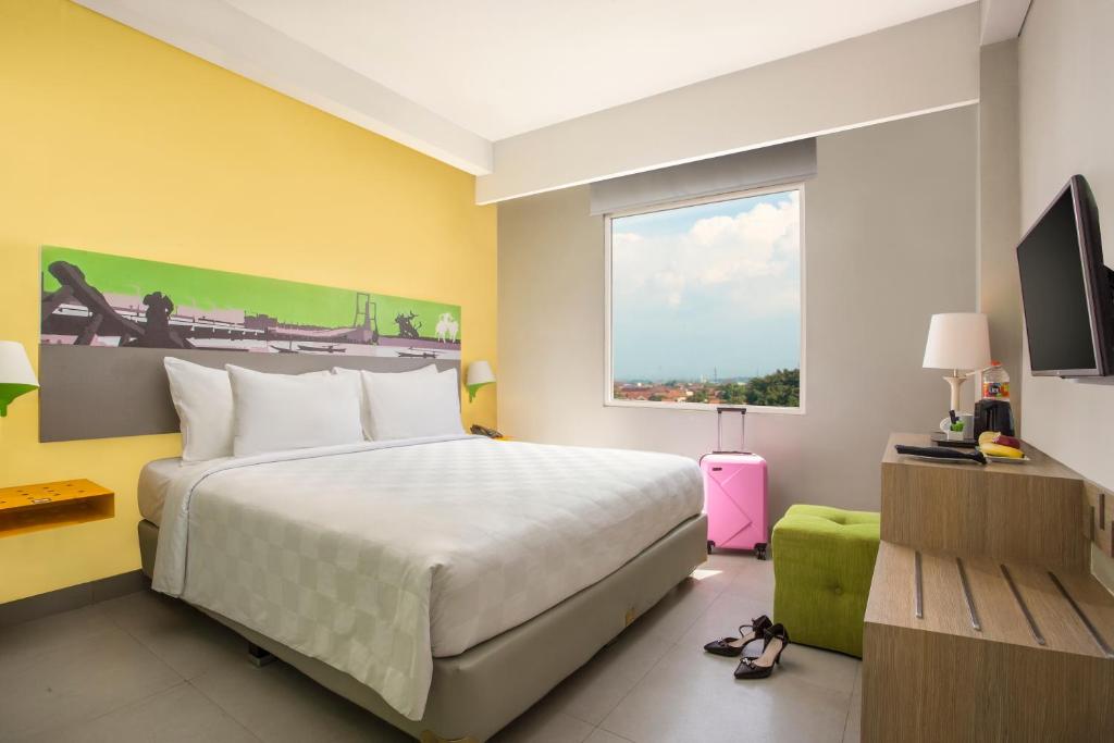 ein Schlafzimmer mit einem großen Bett und einem Fenster in der Unterkunft KHAS Surabaya in Surabaya