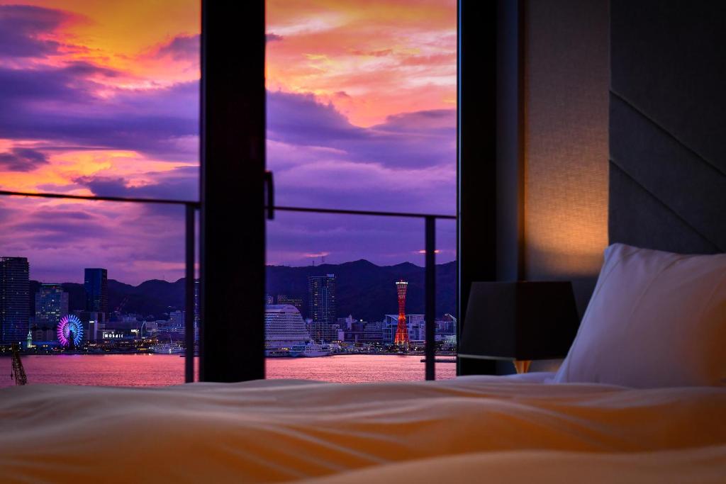 a bedroom with a view of a city skyline at Centurion Hotel&Spa Vintage Kobe in Kobe