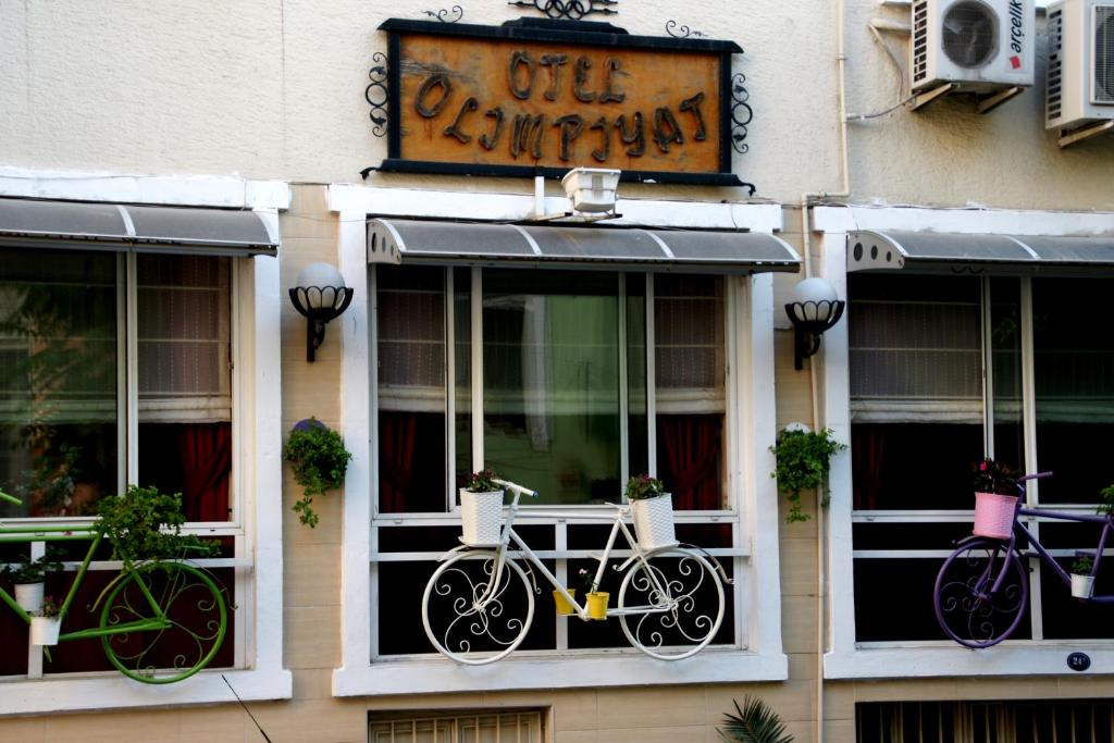 two bikes are hanging in the windows of a building at Olimpiyat Hotel Izmir in İzmir