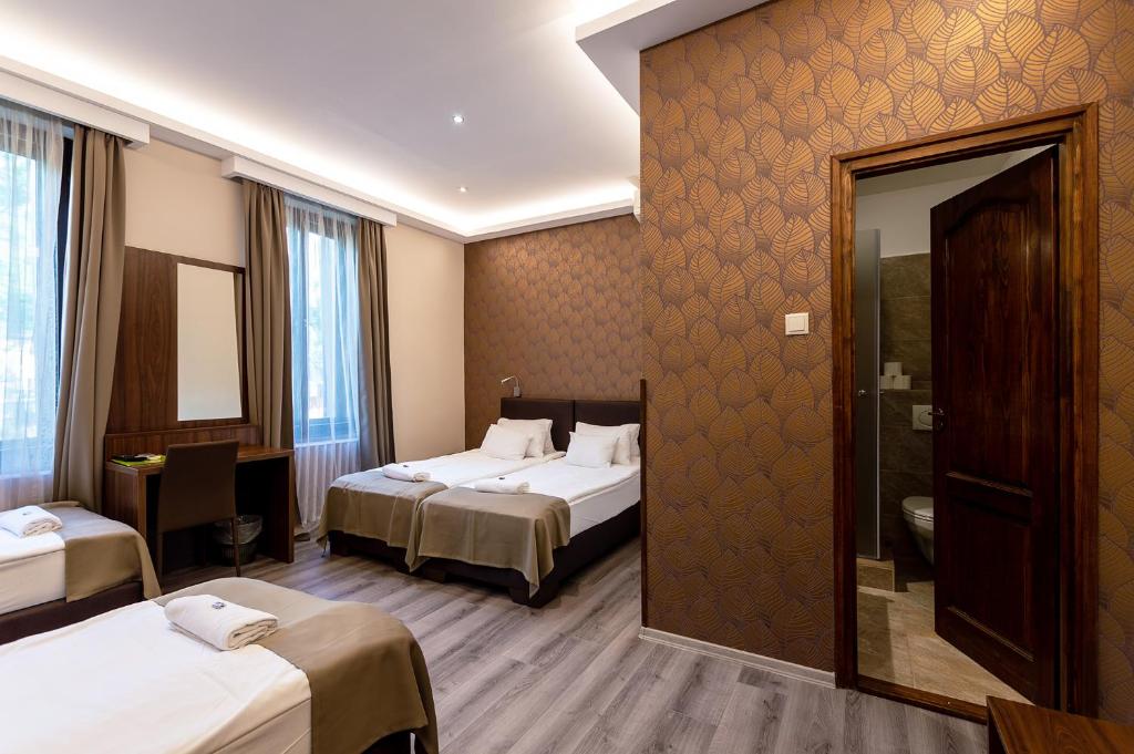 Habitación de hotel con 2 camas y espejo en Vén Diófa De Lux Panzió en Szeged