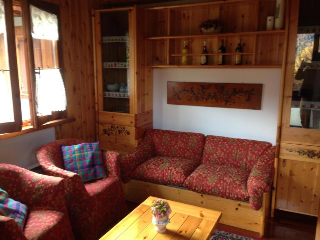 フォルガリダにあるNevi Apartmentのリビングルーム(赤いソファ2台、木製テーブル付)