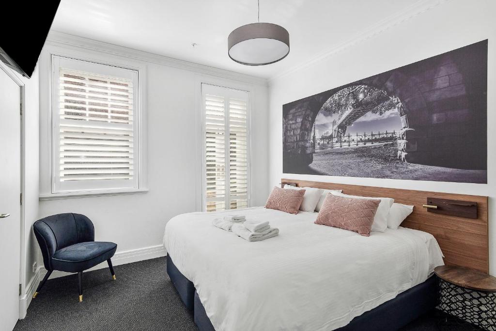 雪梨的住宿－Criterion Hotel Sydney，一间卧室配有一张大床和一把椅子