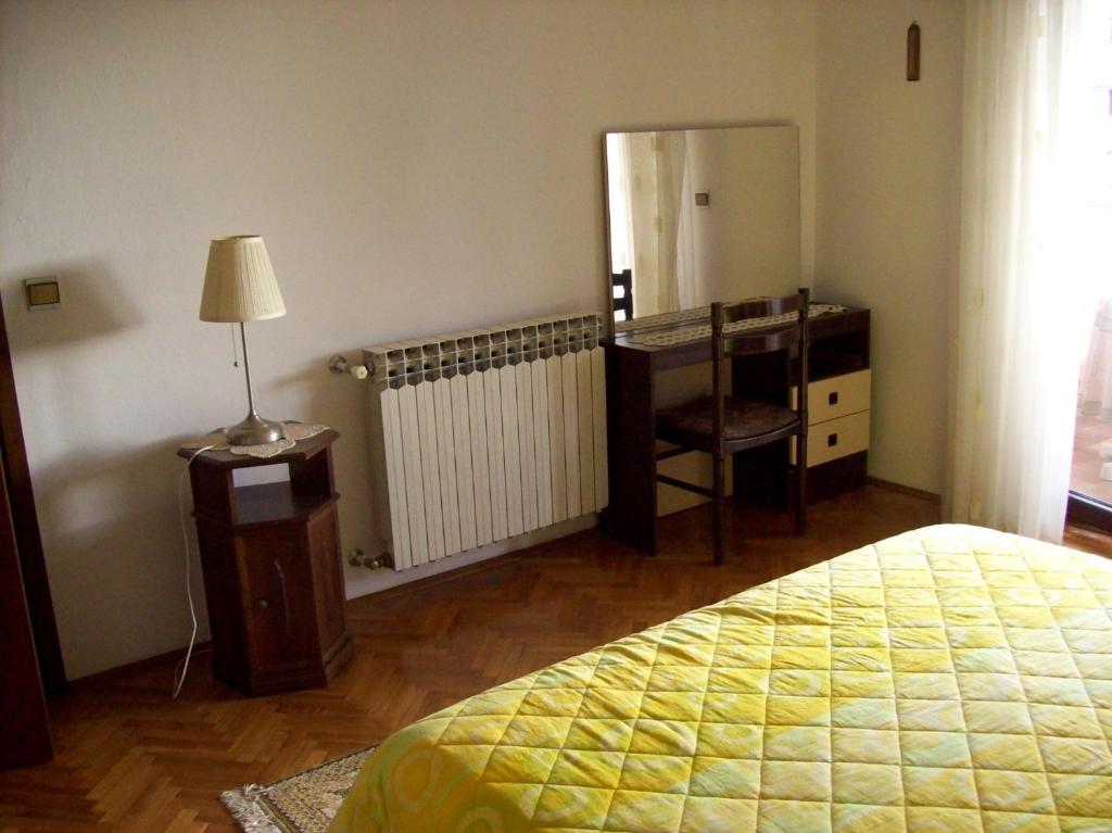 a bedroom with a bed and a desk and a lamp at Apartment Degobbis in Rovinj