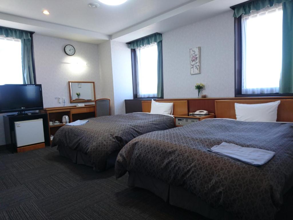 Postel nebo postele na pokoji v ubytování Terminal Hotel Matsuyama