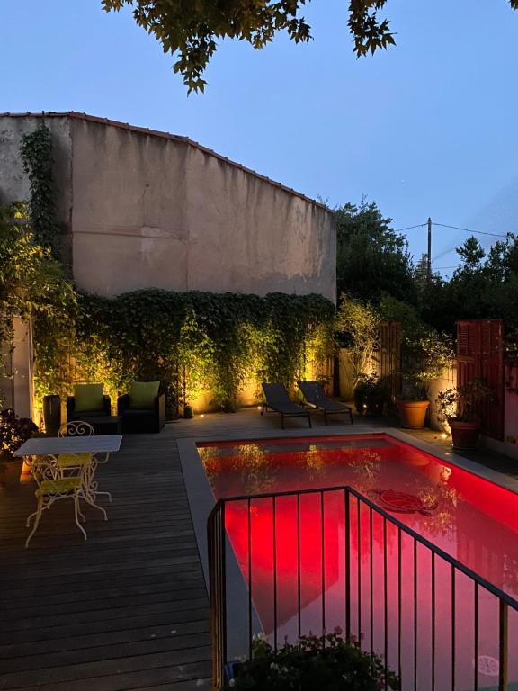 een achtertuin met een zwembad met rode verlichting bij Avignon Campagne in Avignon