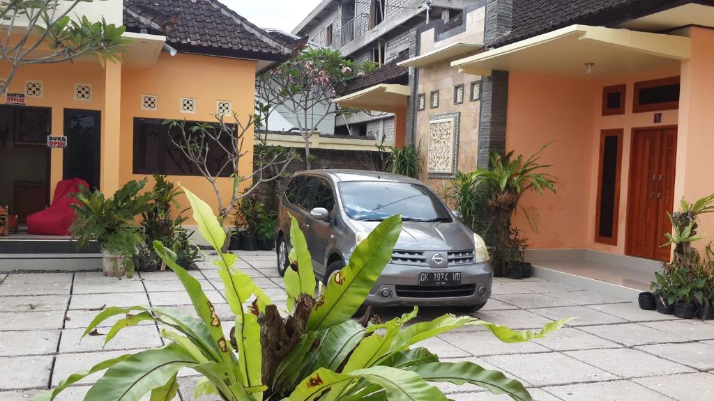 a small car parked in front of a house at Jepun Bali hotel negara in Negara