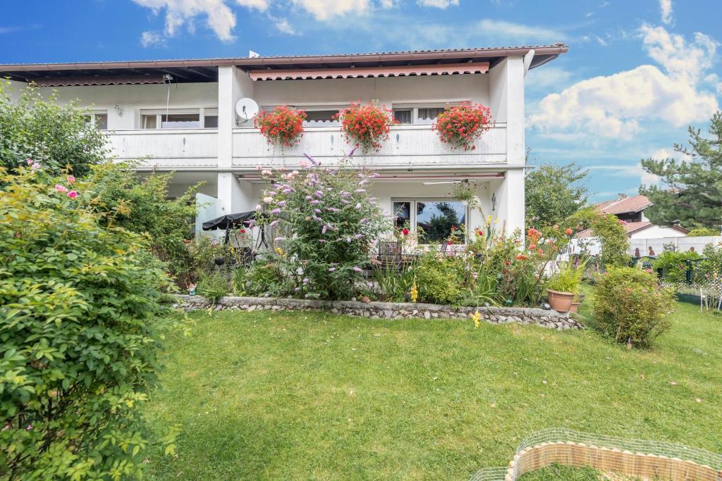 uma casa branca com caixas de flores num quintal em Haus Schild em Grassau