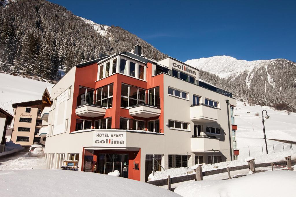ein Gebäude im Schnee vor einem Berg in der Unterkunft Hotel Garni & Aparthotel COLLINA in Ischgl