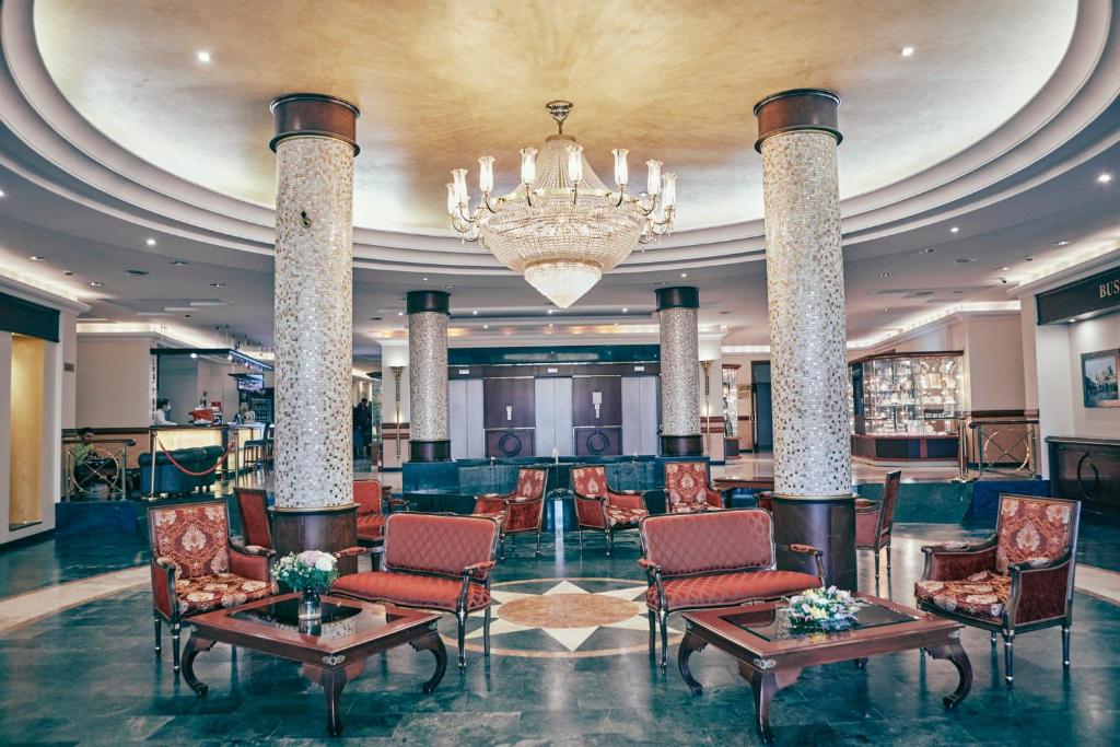 a hotel lobby with chairs and a chandelier at Ring Premier Hotel in Yaroslavl