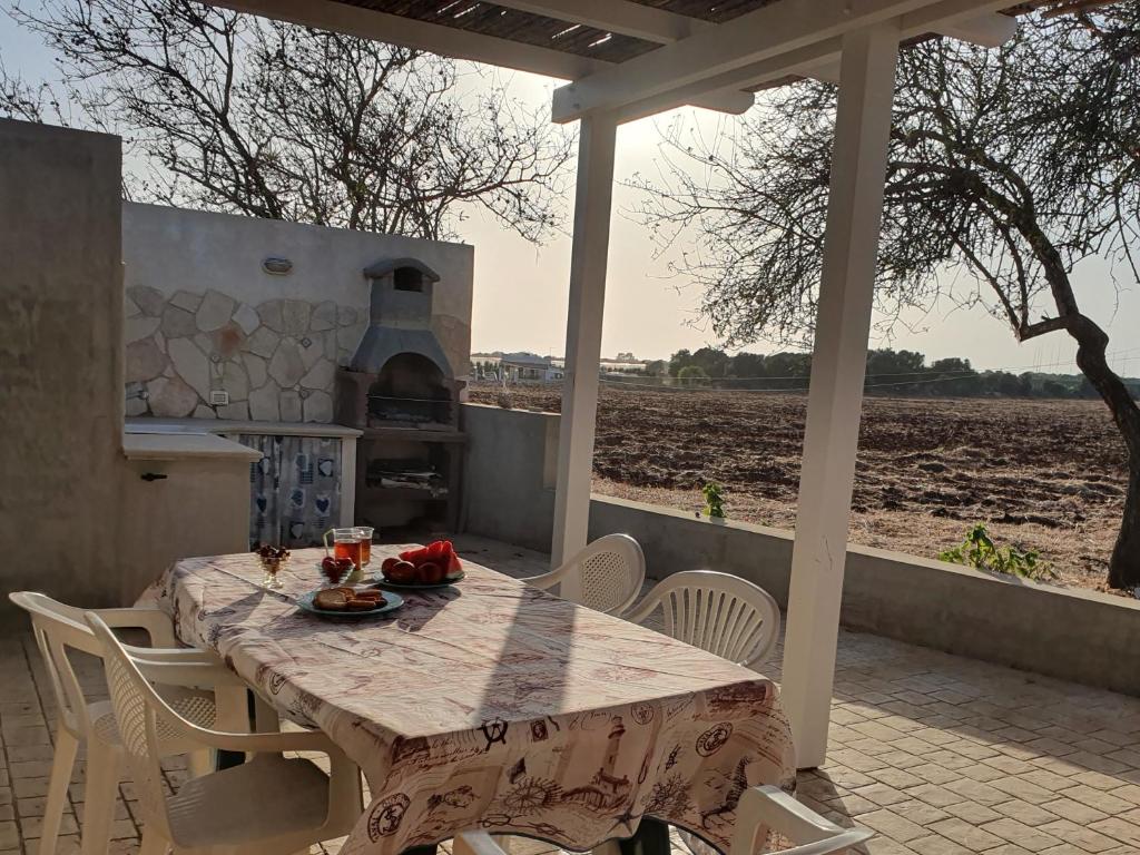 a table and chairs on a patio with a field at Casa dei Colori in Portopalo