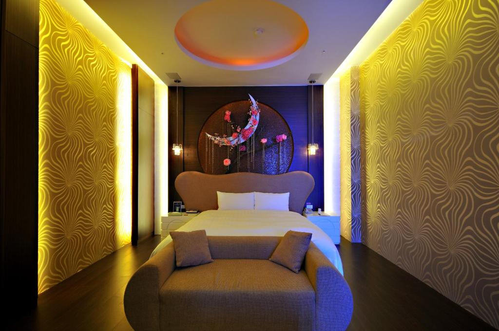 ein Schlafzimmer mit einem Bett und einem Stuhl darin in der Unterkunft Dubai Motel in Yilan