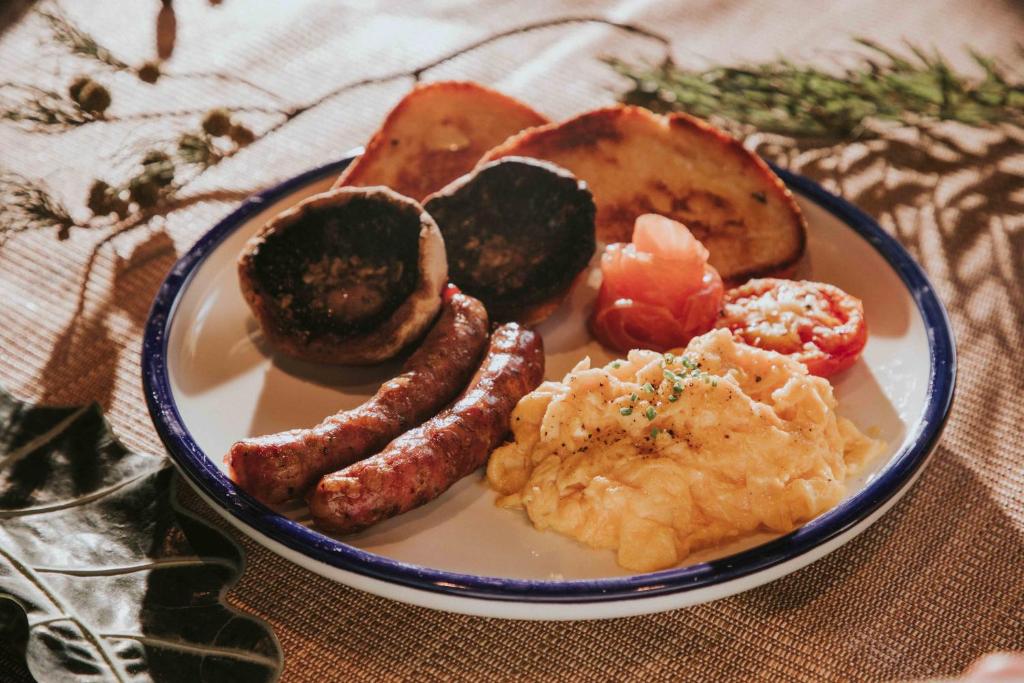 a plate of breakfast food with sausage and other foods at Kimpton Da An Taipei- an IHG Hotel in Taipei
