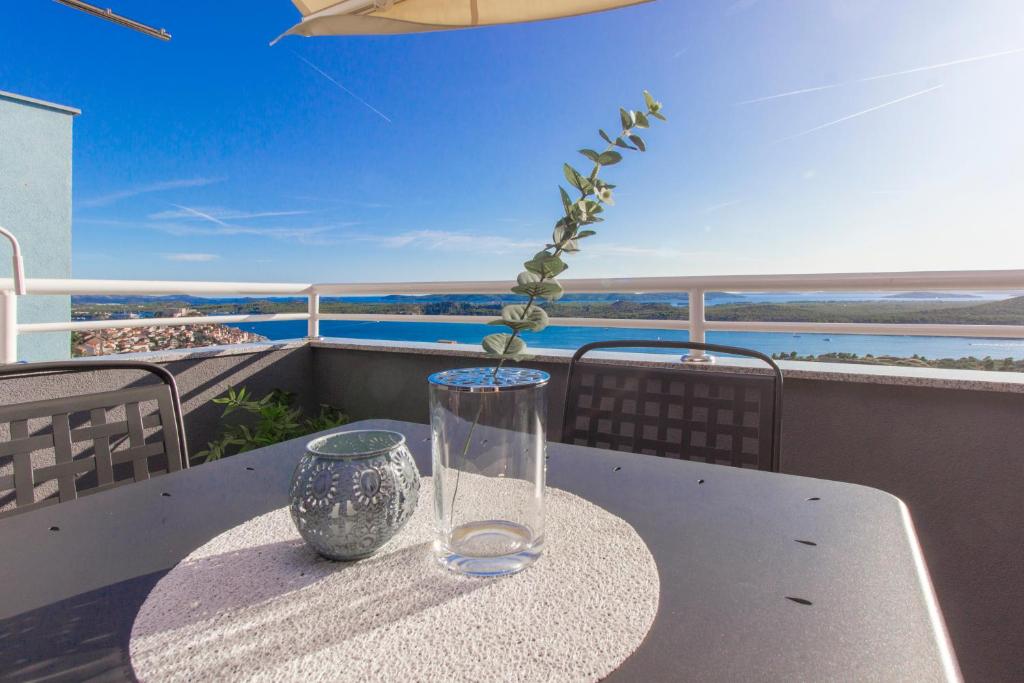 szklaną wazę siedzącą na stole na balkonie w obiekcie Apartment Sea View w Szybeniku