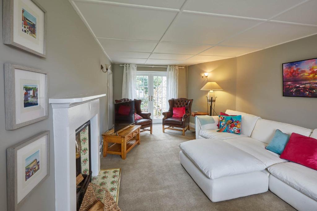 a living room with a white couch and a fireplace at Host & Stay - Arncliffe View in Egton