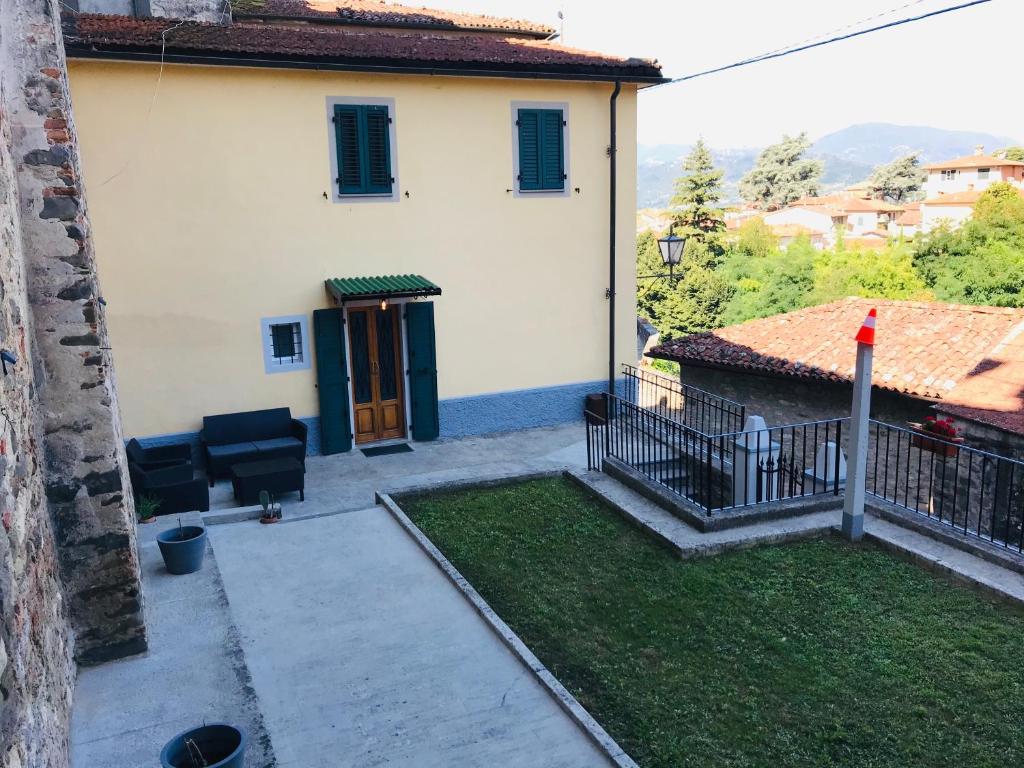 a white house with a door and a yard at Casa Luna - Private Cottage -Exclusive Private Garden in Barga