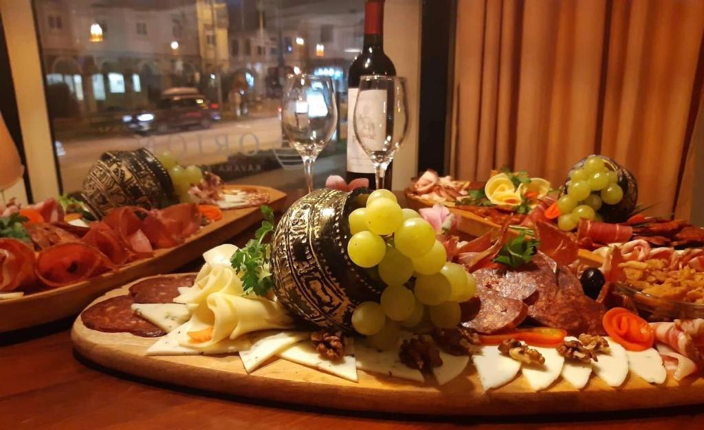 una mesa con dos platos de comida y copas de vino en Hotel Slavonija, en Vinkovci