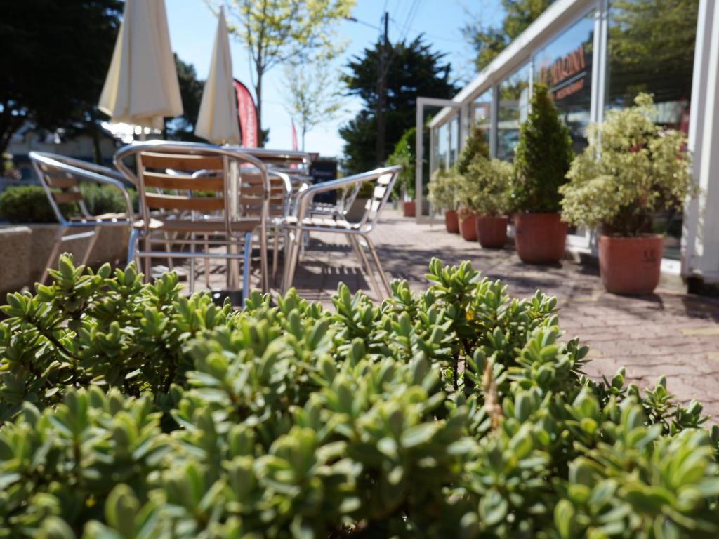 a group of chairs and tables in a patio at Hotel et Studios Le Marina Baie de La Baule in Pornichet