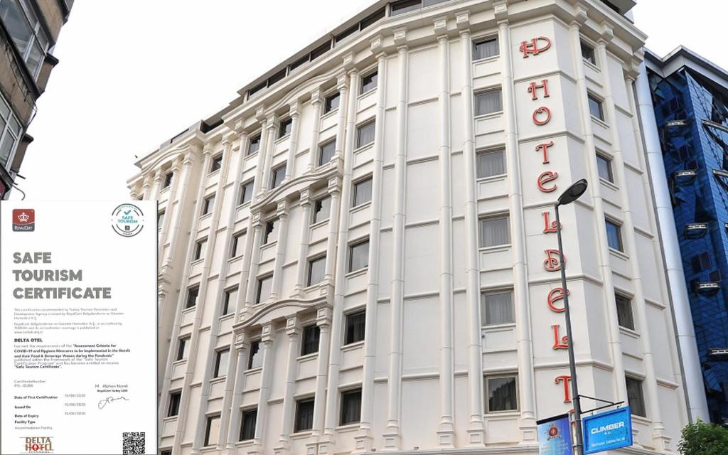 um edifício branco com um sinal em frente em Delta Hotel Istanbul em Istambul