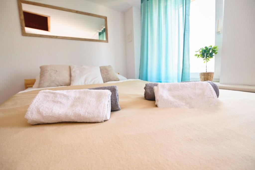 a large bed with two pillows on top of it at Regem Apartments Waryńskiego in Warsaw