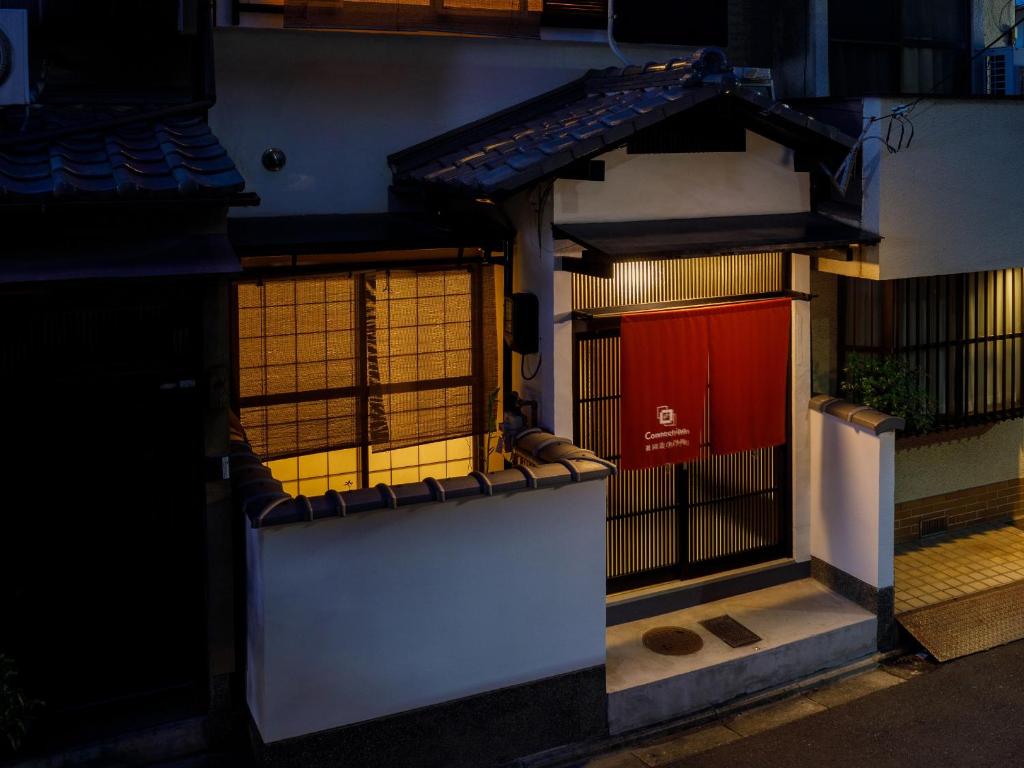 een gebouw met een poort en een rode deur bij Connect inn Gion-Bishamoncho in Kyoto
