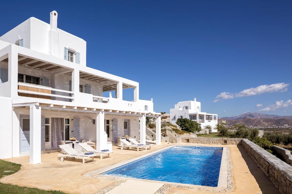 a white villa with a swimming pool in front of it at Naxian Collection - Small Luxury Hotel of the World in Stelida