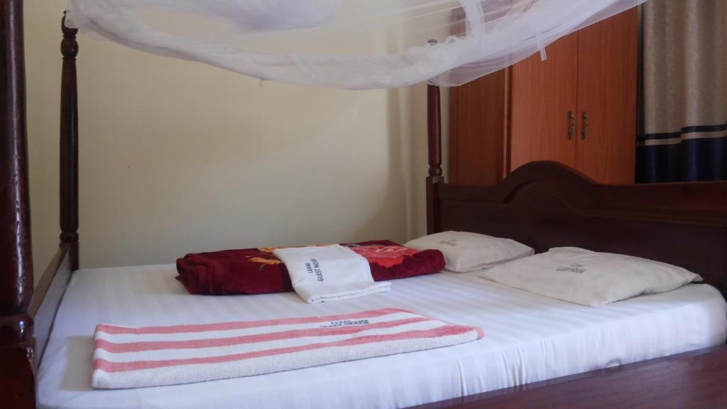Una cama con dos toallas encima. en Leam Guesthouse, en Moyo