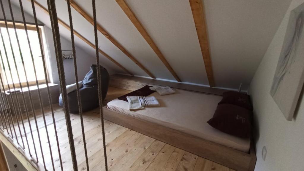 a small room with a bed in a attic at Brvnare Ljubojević in Kraljevo