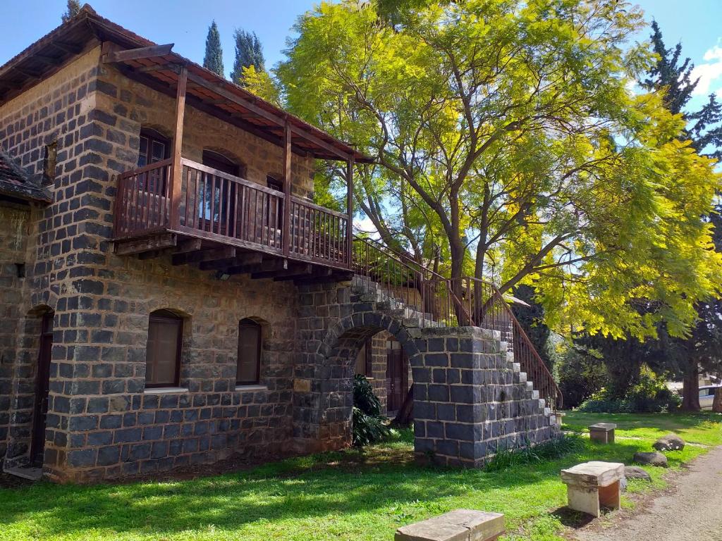 a brick building with a balcony on top of it at Kfar Giladi Hotel in Kefar Gil‘adi