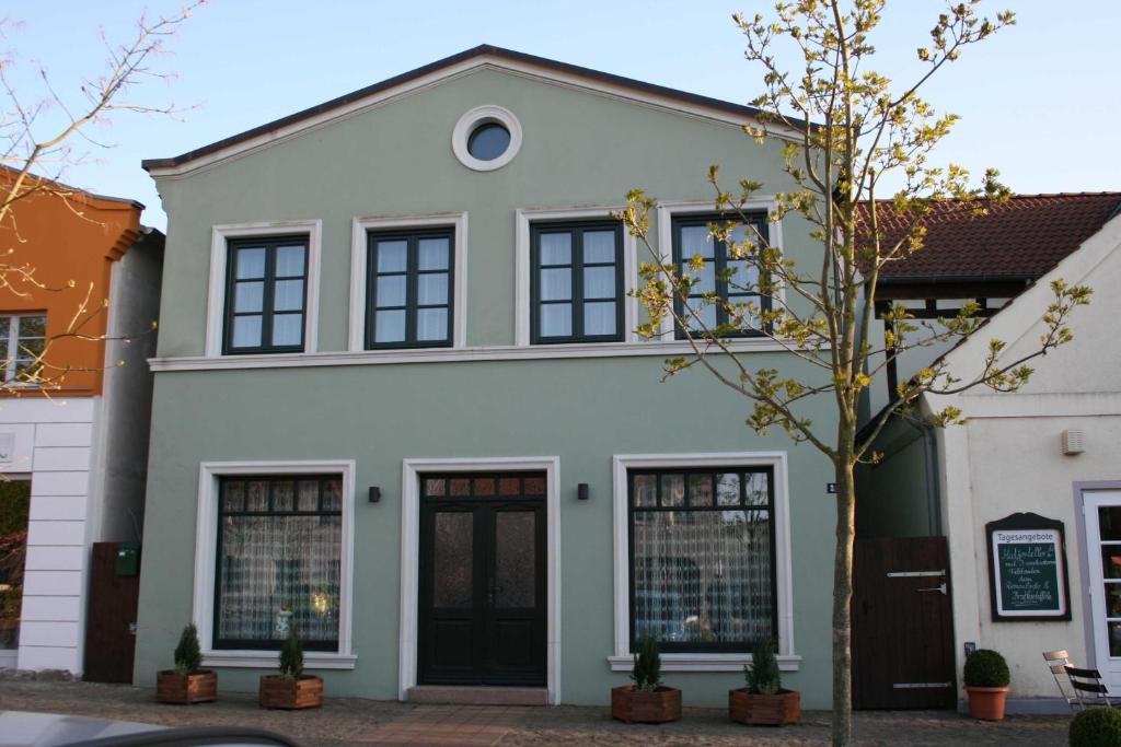 a white house with black windows at Gaestehaus Celina_ WE32747 in Gingst
