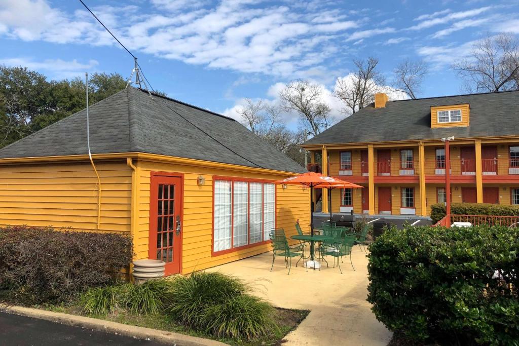 a yellow house with a patio and a table at Baymont by Wyndham Selma in Selma