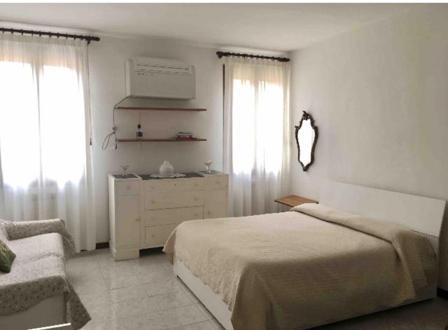 ヴェネツィアにあるSILVIA'S HOMEのベッドルーム1室(ベッド1台、ドレッサー、窓2つ付)