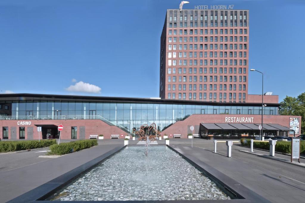 einen Brunnen in der Mitte einer Straße vor einem Gebäude in der Unterkunft Van der Valk Hotel Hoorn in Hoorn