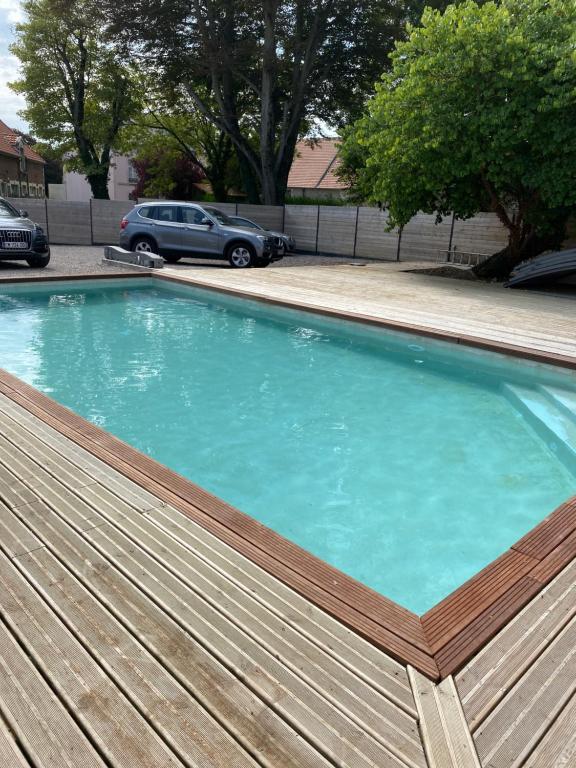 una gran piscina con terraza de madera en Les lodges du chateau, en Marquise