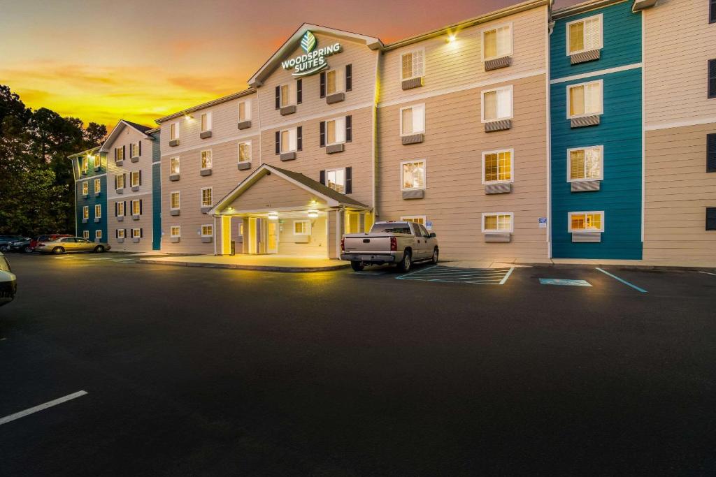 a truck parked in a parking lot in front of a hotel at WoodSpring Suites | North Charleston Airport I-526 in Charleston