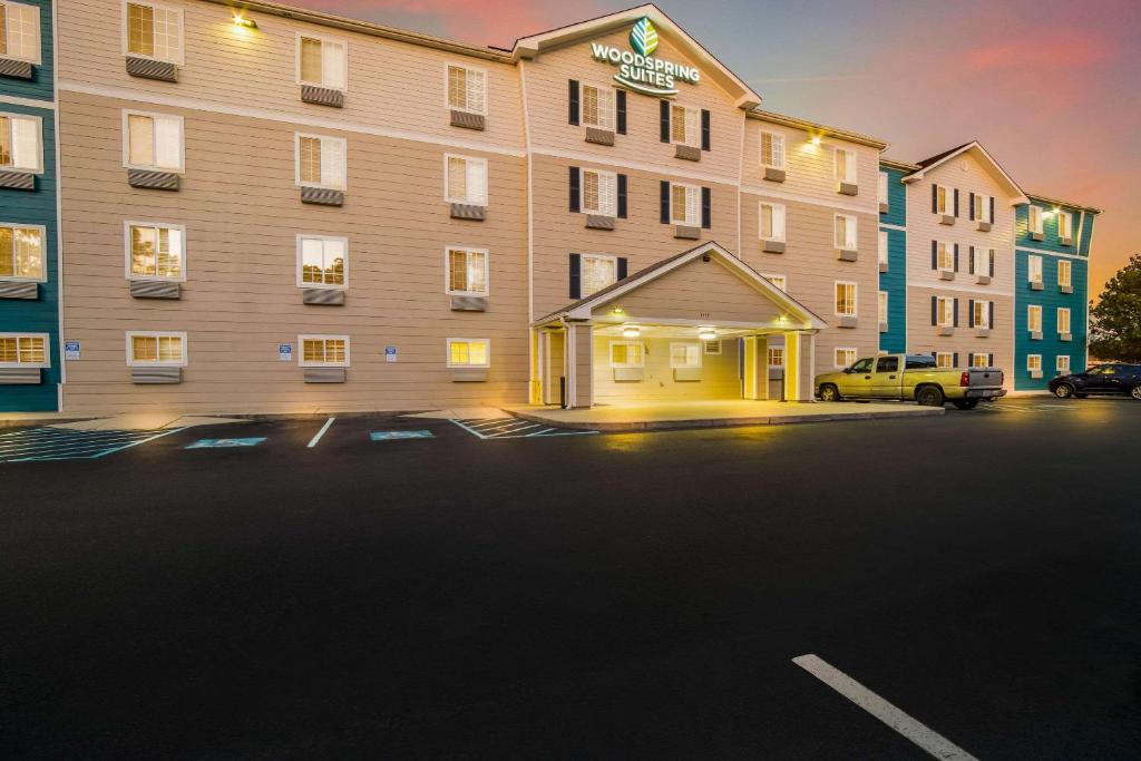 a hotel with a parking lot in front of it at WoodSpring Suites | North Charleston Airport I-526 in Charleston