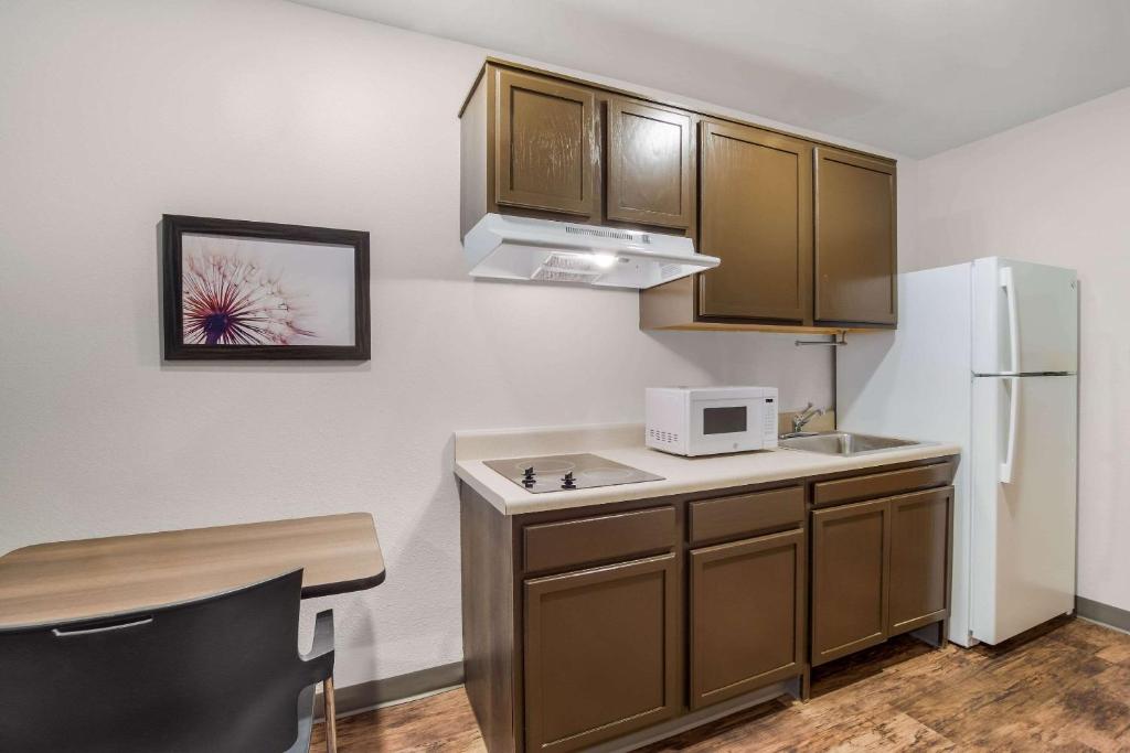 a kitchen with a sink and a white refrigerator at WoodSpring Suites | North Charleston Airport I-526 in Charleston