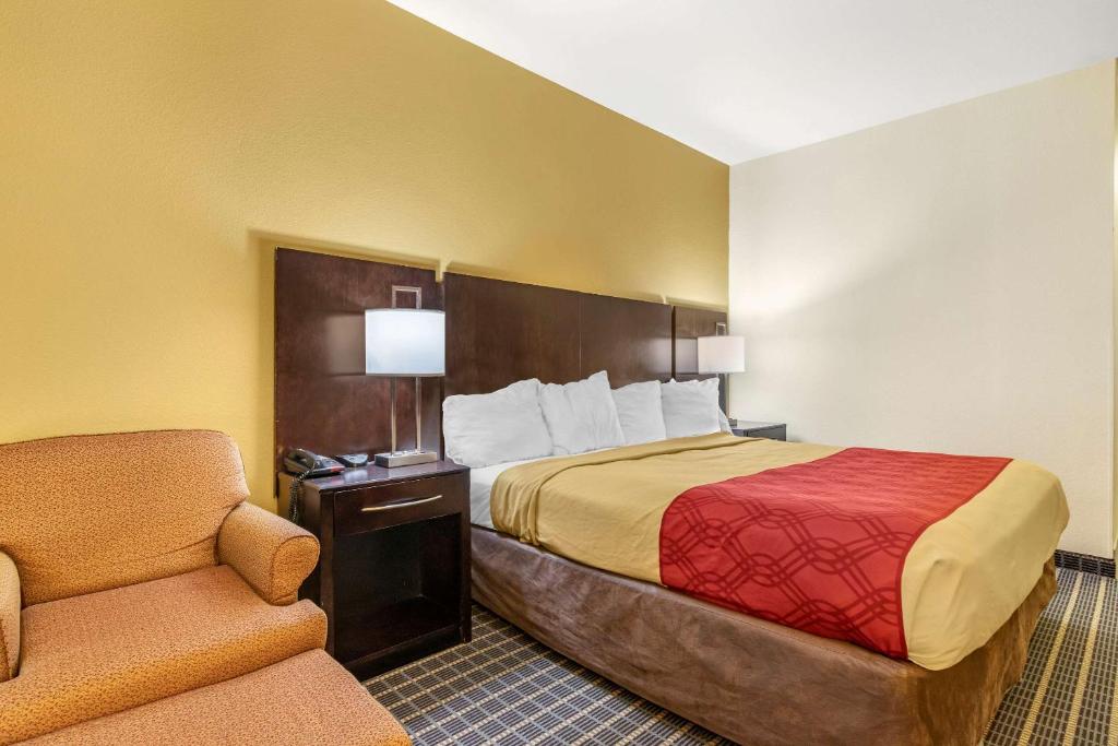 a hotel room with a bed and a chair at Econo Lodge in Brunswick