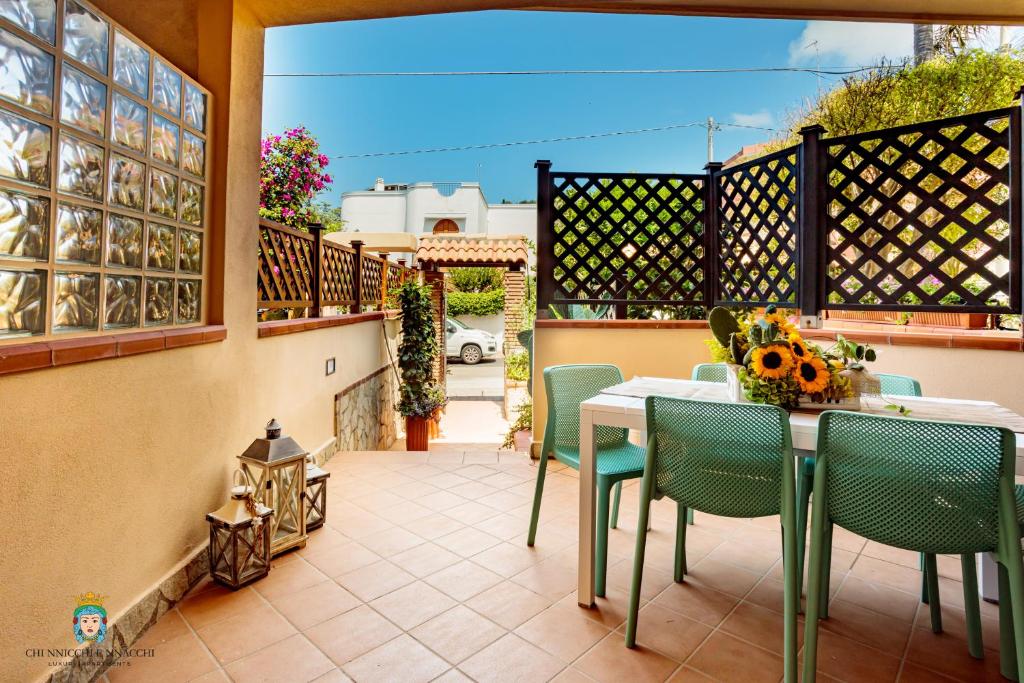 um pátio com uma mesa e cadeiras numa varanda em Chi nnicchi e nnacchi - Luxury apartments em Milazzo