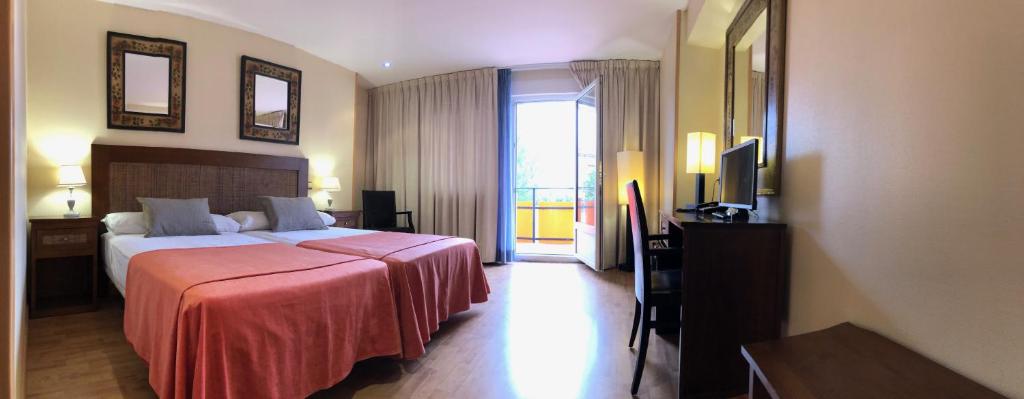 Habitación de hotel con cama y TV en HOTEL V.CIUDAD en Aranda de Duero