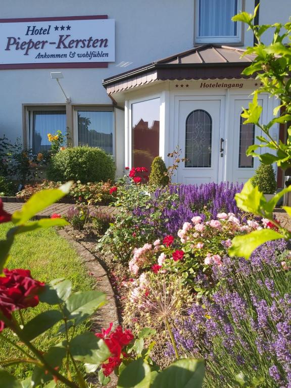 un jardin avec des fleurs en face d'une maison dans l'établissement Hotel Pieper-Kersten, à Bad Laer