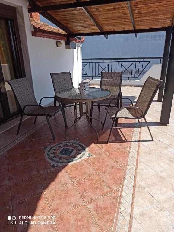 a patio with a table and chairs on a balcony at Olympus and Sea View Apartments in Nea Michaniona