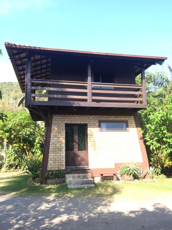 a small house with a porch and a door at Zululand Bangalôs in Guarda do Embaú