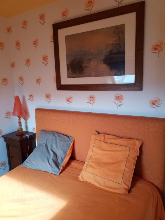 a bedroom with a bed and a picture on the wall at Ker Kistin in Fouesnant