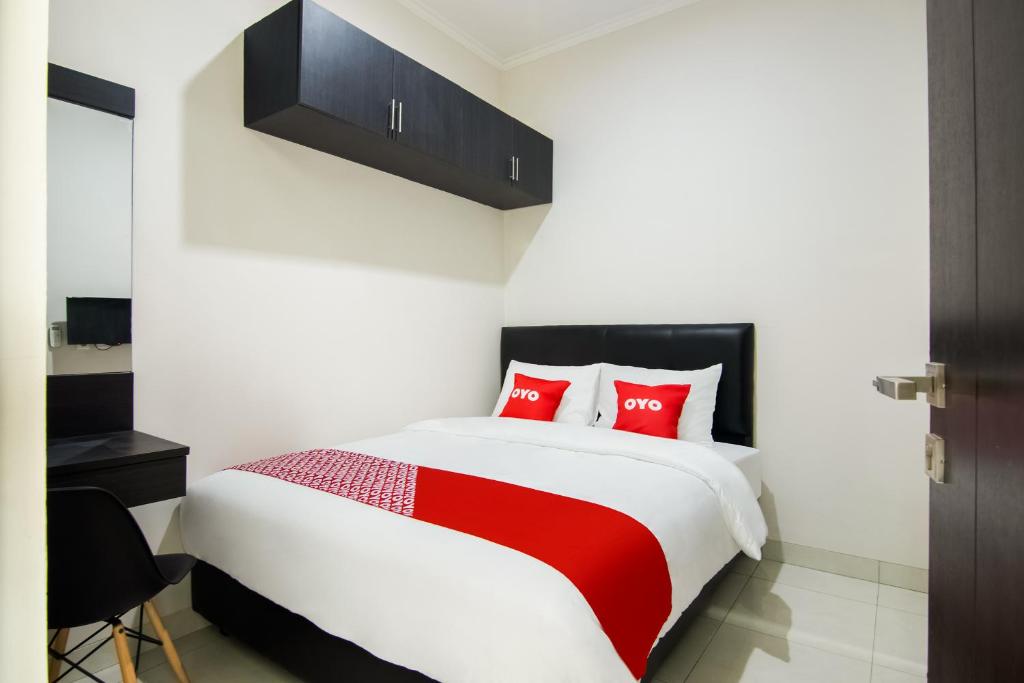 a bedroom with a large bed with red pillows at OYO 3826 Columbus Residence K11 in Karawang